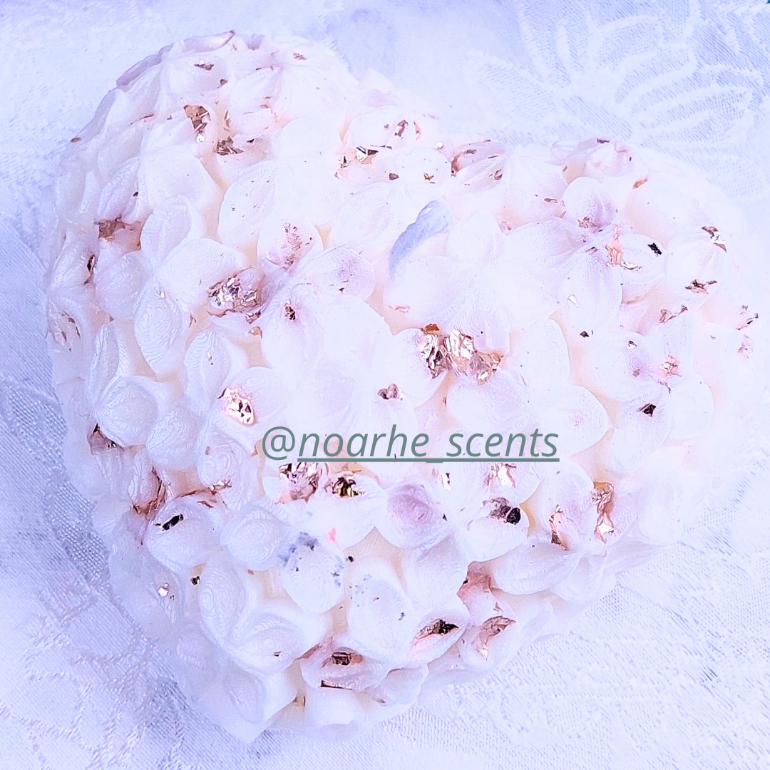 La vela perfecta para los enamorados, encenderá los sentidos con su encanto. Su delicada forma de corazón, decorada con pequeñas flores y chispas de pan de oro, la convierte en el complemento perfecto de veladas&nbsp;mágicas y románticas.

Puedes personalizarla en el color que prefieras, con o sin aroma.